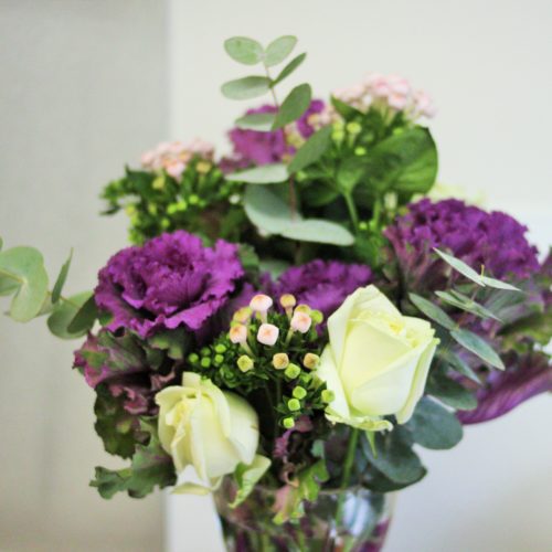 bunch of flowers with purple and white blooms and lots of green leaves