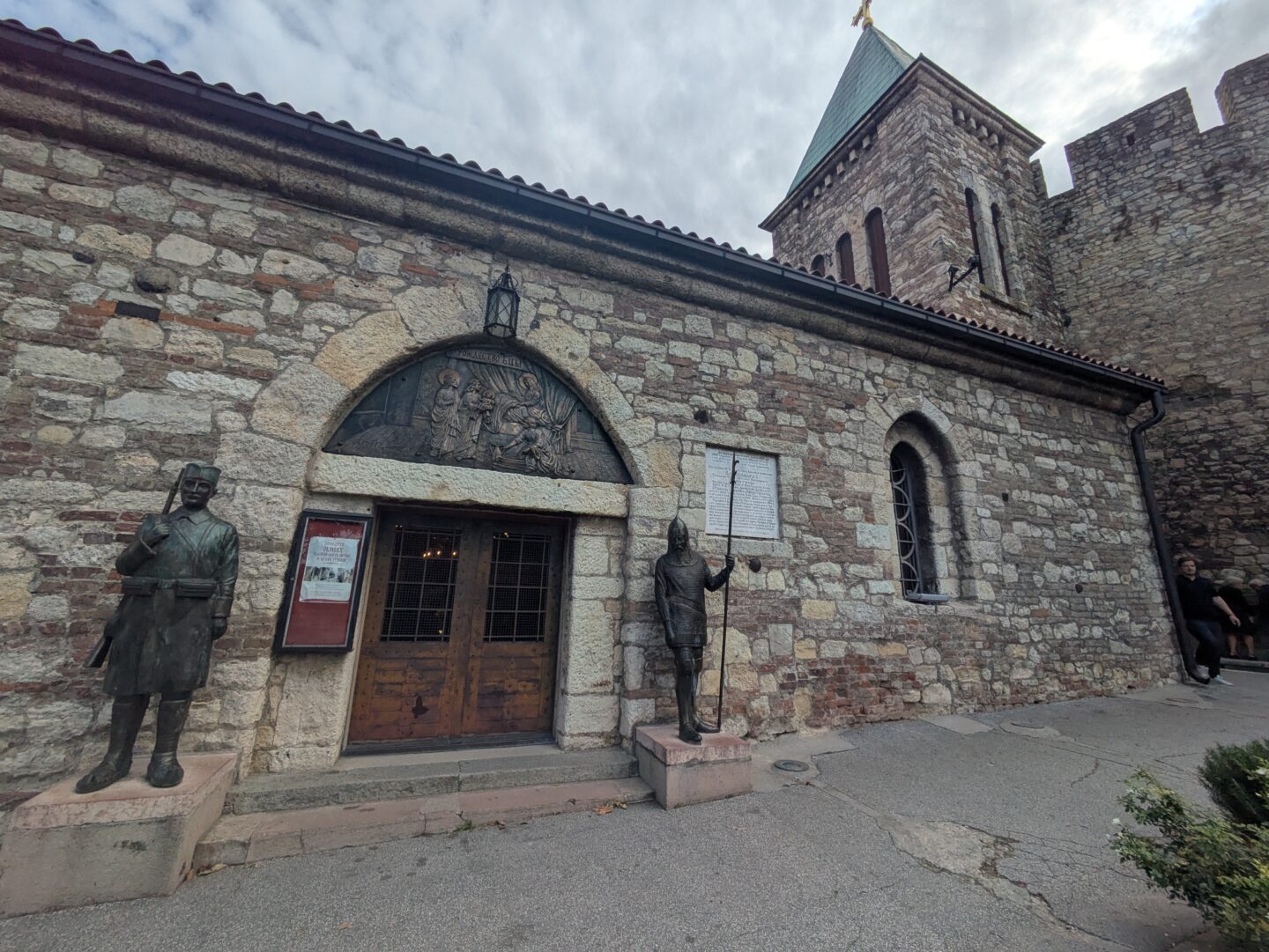 a cobbled church with two metal guards outside