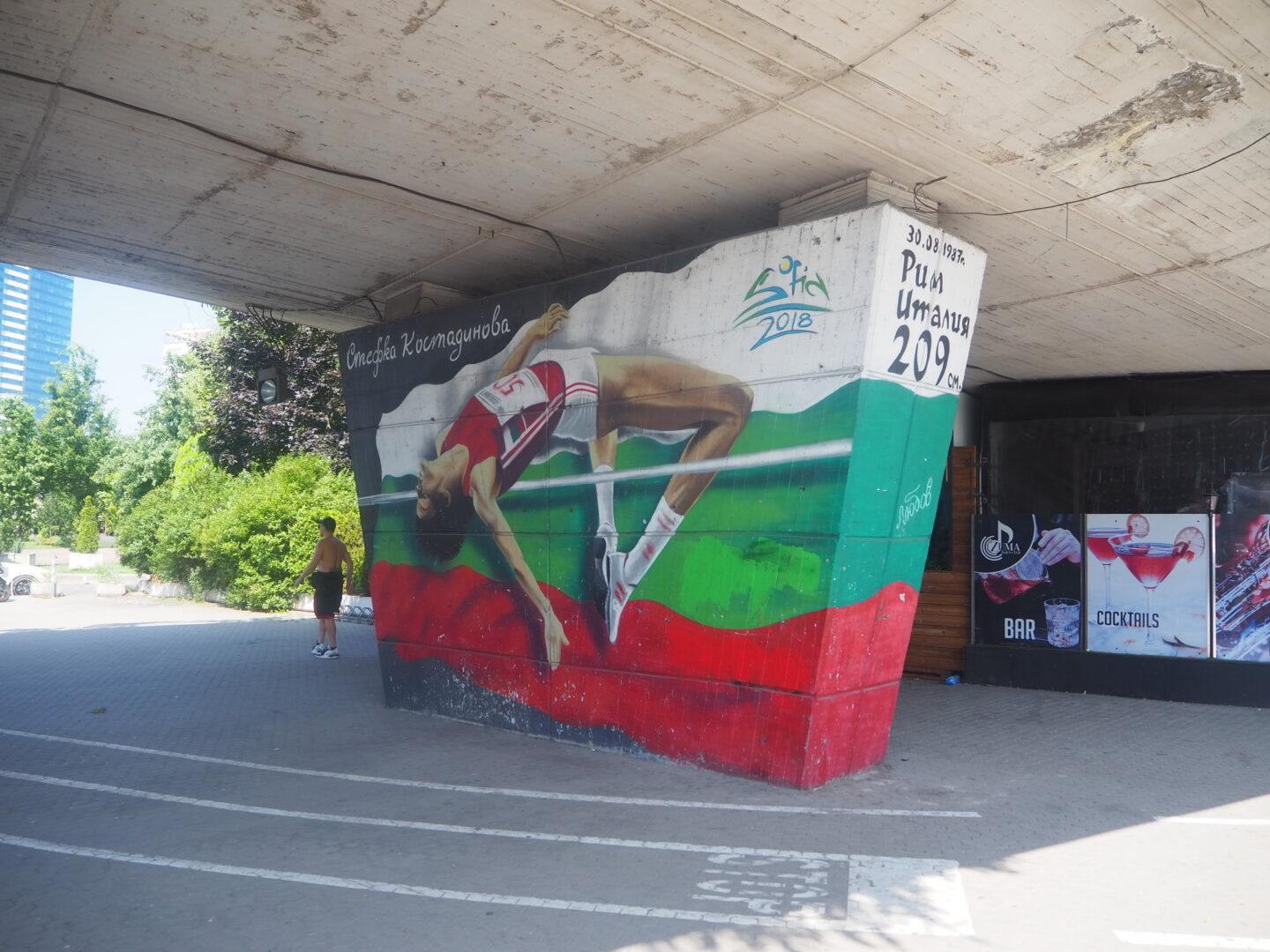 Street art showing a person doing the high jump. The background of the photo is the Bulgarian flag
